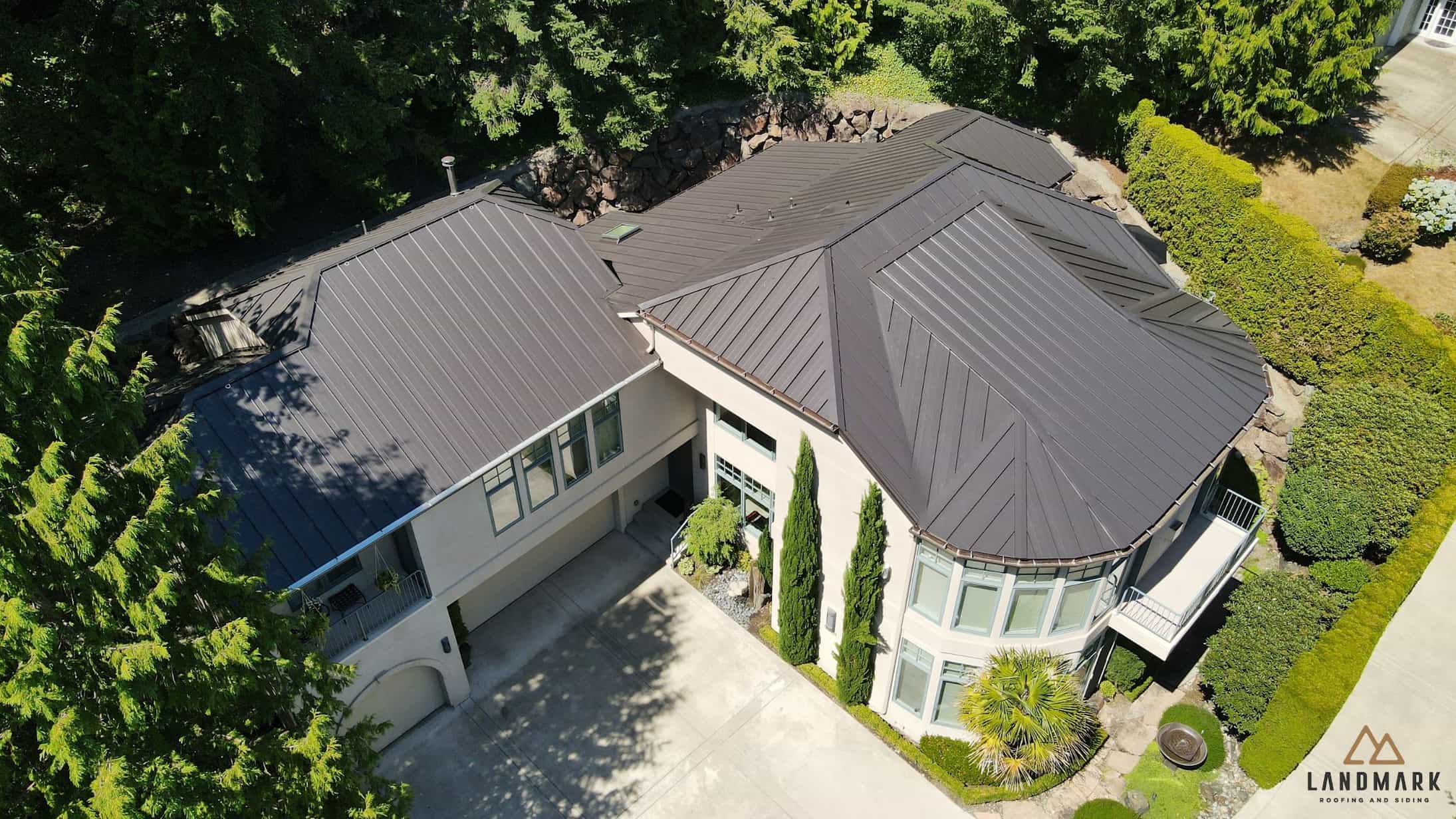 Aerial view of a modern home in Redmond, WA with dark standing seam metal roofing installed by Landmark Roofing & Siding