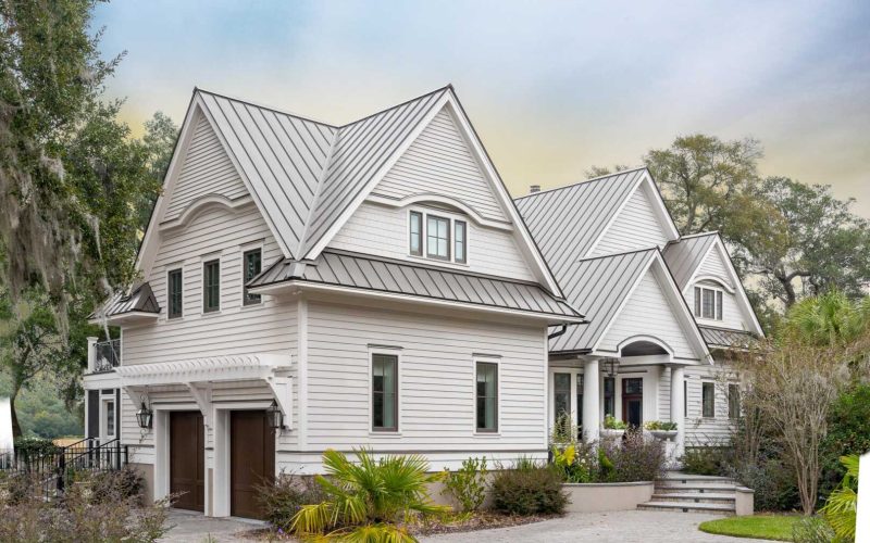 A modern two-story house with gray siding and a white metal roof in Bellevue WA